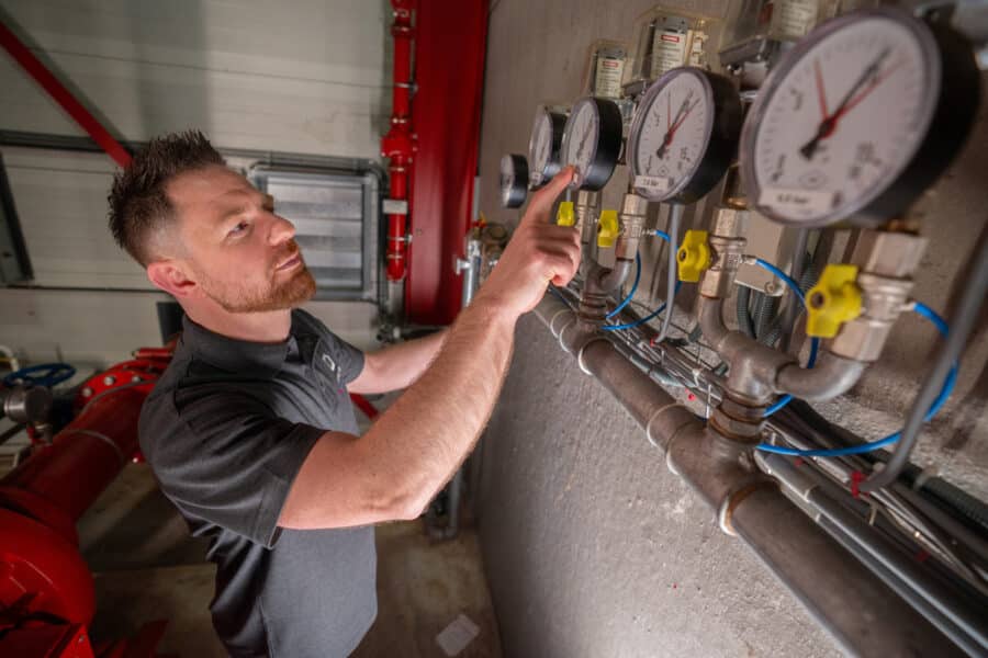 Monteur voert onderhoud uit aan sprinklerinstallatie